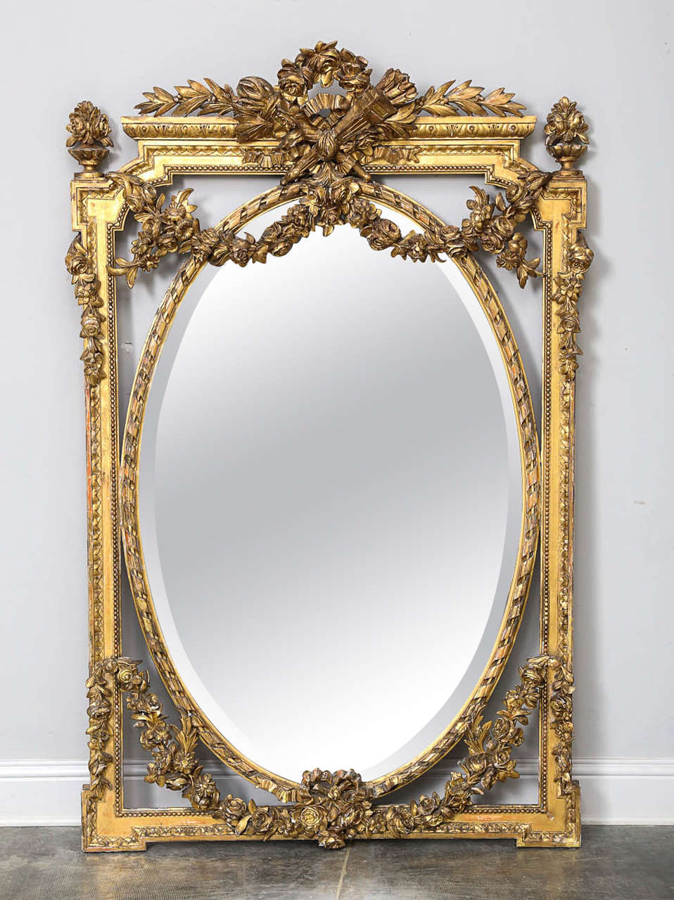 Outstanding mirror with oval mirror suspended in ornate rectangular frame. Beautiful carved and gilded swags of flowers.

Established in 1979, Joyce Horn Antiques, ltd. continues its 36 year tradition of being a family owned and operated business