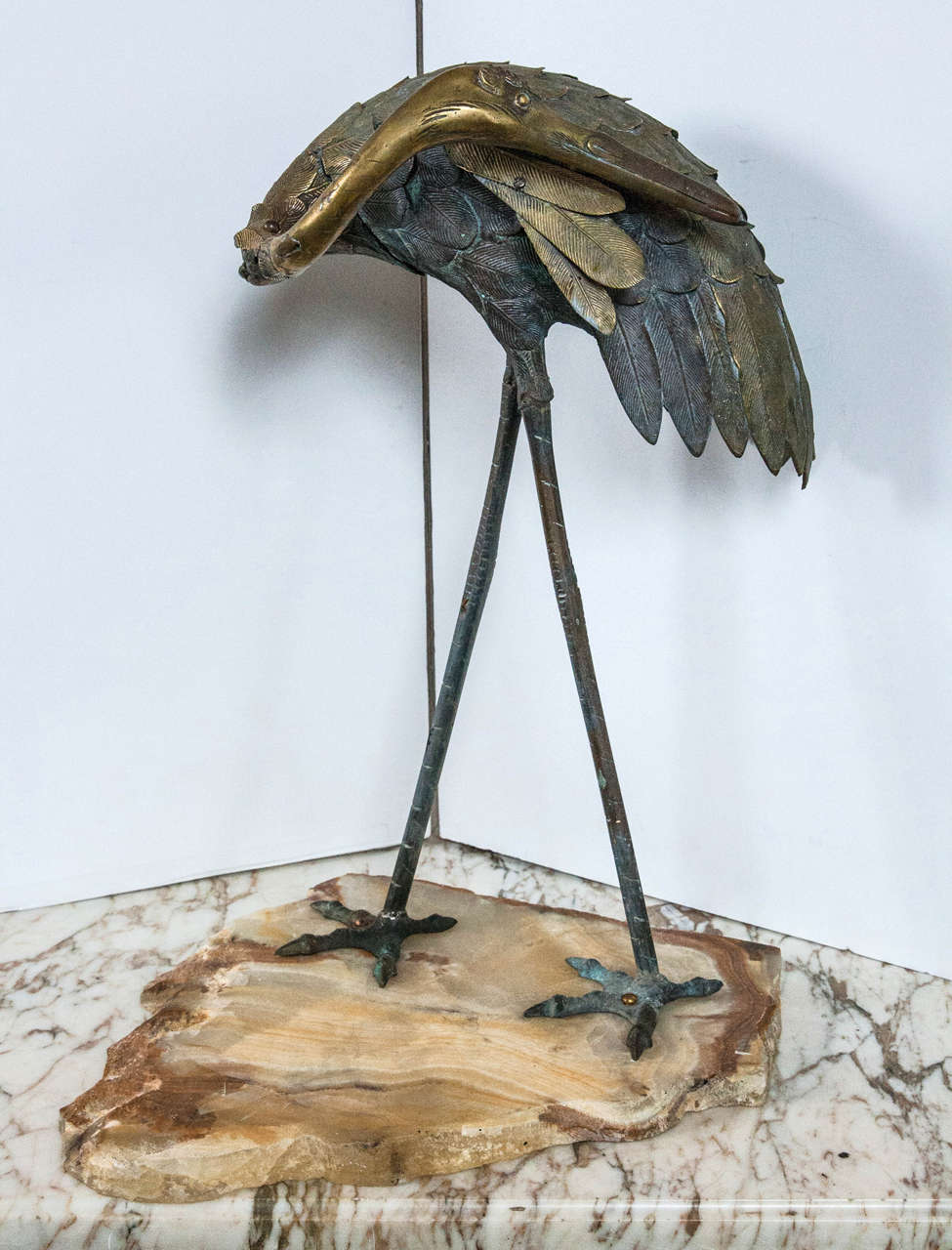 This crane is mounted on a slab stone base.  beautifully chased feathers, head,  legs and feet.  The head turned to its left.  Cast in separate pieces, and  attached with screws. Dimensions include the stone base.