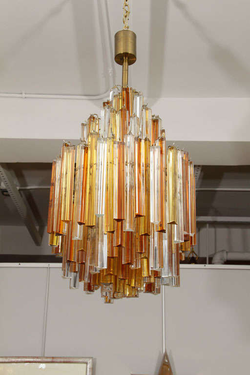 A striking Venini chandelier composed of clear, gold and amber triedri crystals.