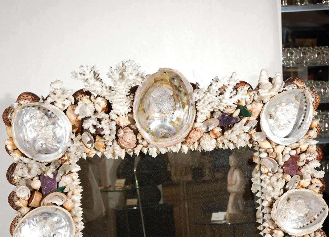 An elaborate and rare hand made sea shell and coral encrusted wall mirror with amethyst and malachite elements designed by Anthony Redmile.  Mirror also features a silver plated planter for creating beautiful arrangements. Mirror is signed on the