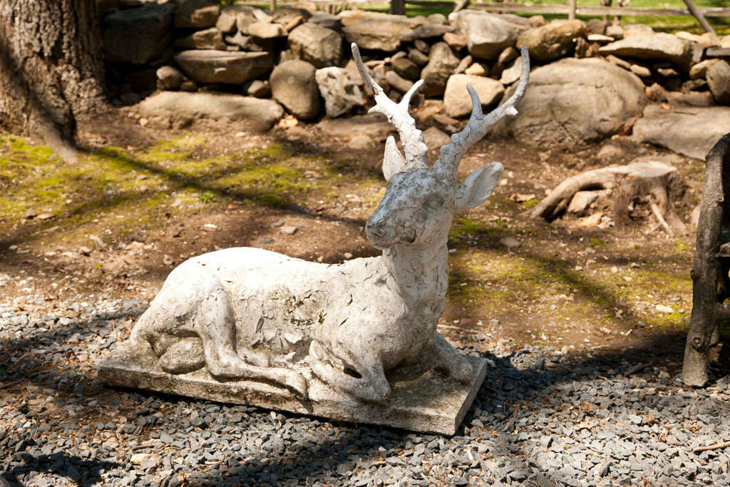 Painted large stag rests on a rectangular platform