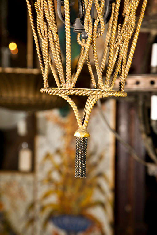 Gilt metal rope and tassel pendant light with four bulbs.