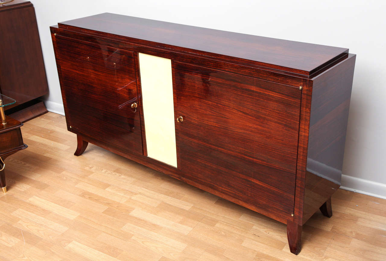 Elegant Art Deco sideboard with parchment covered center panel. Two interior drawers.