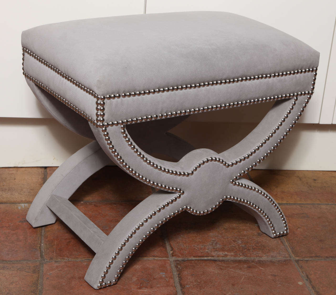 The classical ottoman is small, rectangular and comfortable. The piece is handmade. The chrome nail heads makes the classical lines more pronounced.
The ultraswuede grey textile gives the ottoman a neutral palette that is welcome in every style.