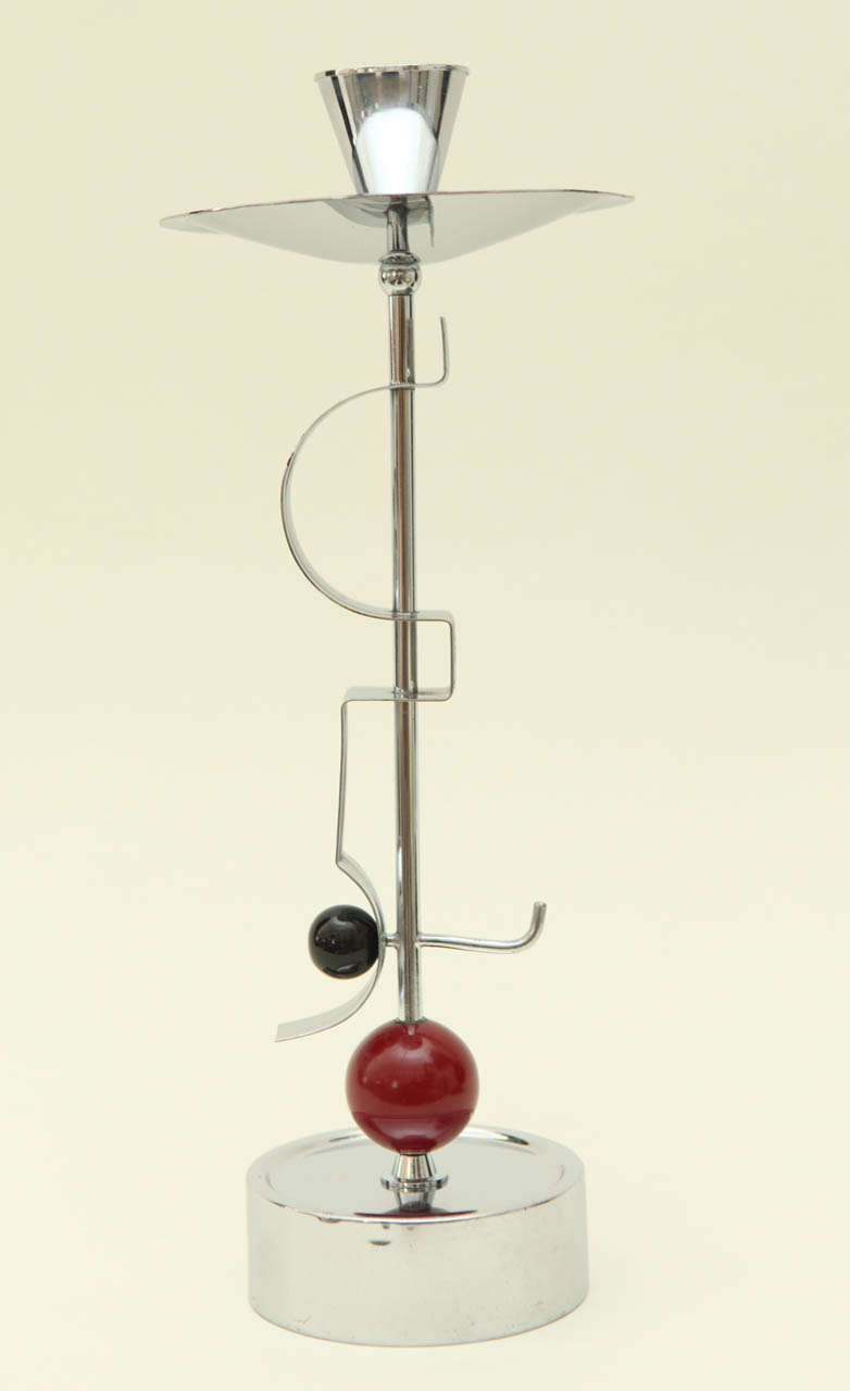 A modernist chrome candlestick with black and cranberry Bakelite accents. Marked on the underside with the WMF WCROM mark (see Image 9).