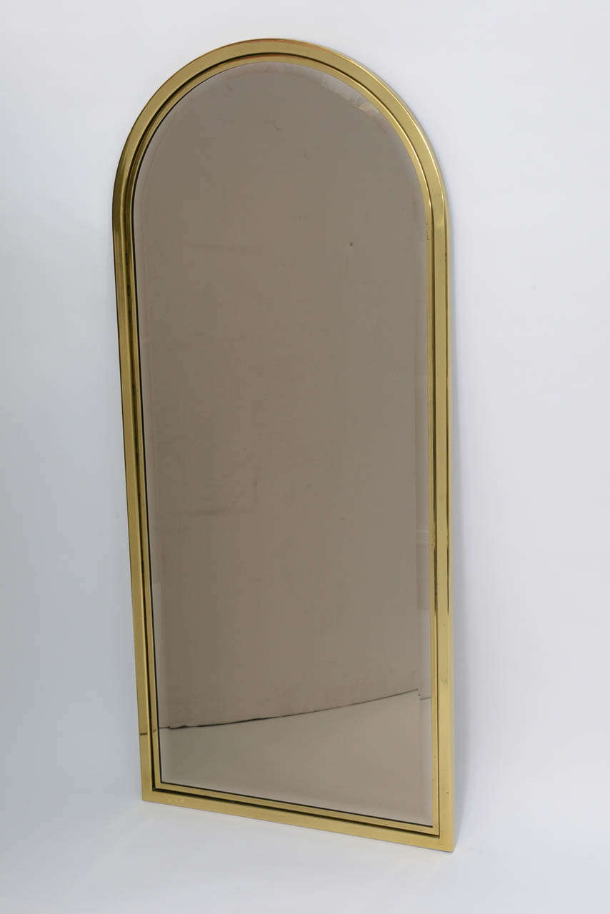REDUCED FROM $1,250....Part of the Connisseur Collection by Drexel, this brass mirror features an a Minimalist arched heavy brass double mold frame with a beveled glass. Perfect for most decor periods, it can be a console or pier mirror, over the