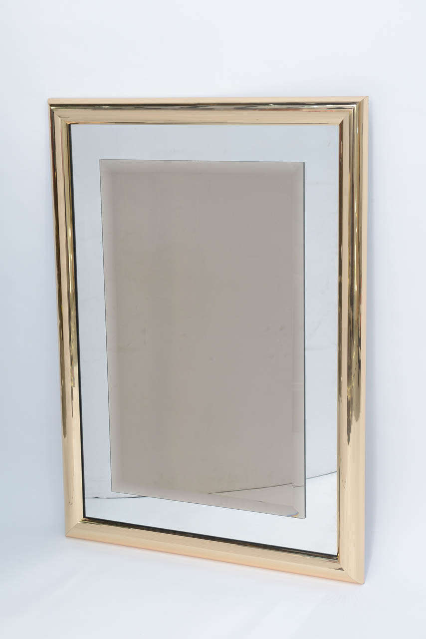 REDUCED FROM $1,250.....Sleek disco era mirror with mirror ball-like micro faceted frame of brass. The mirror features a mirrored glass with a floating bevelled bronze mirror in the centre. Quite elegant and glamorous. 
Measures: 39