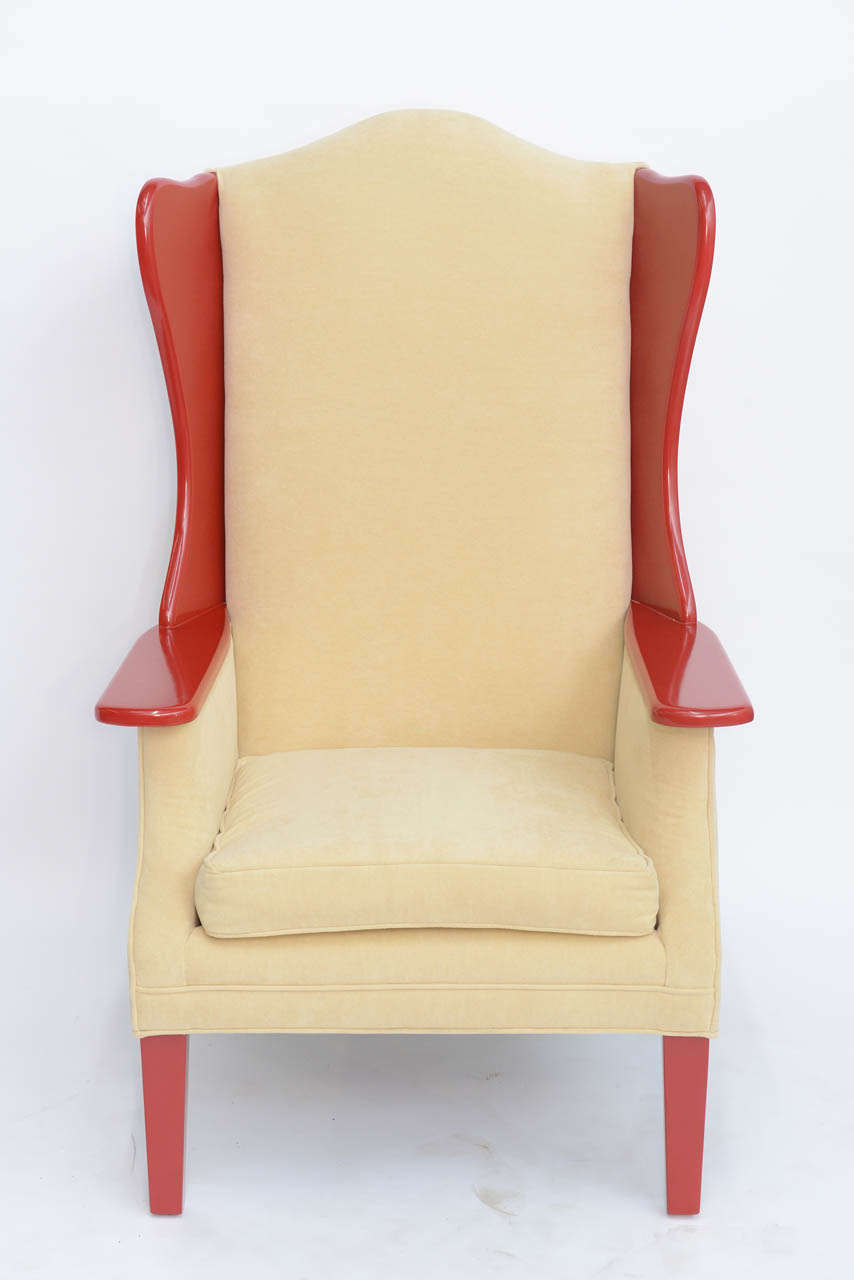 SOLD  A trim and tall  profile is featured with this 1950s upholstered wing back armchair, not to mention the rich Chinese red lacquered maple wings, arms and legs.  Modern, statuesque, with a nod to the past.  Newly upholstered in a creamy doe skin