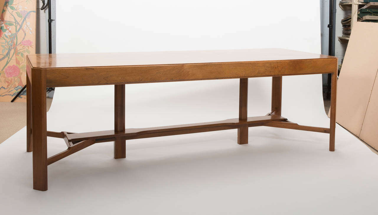 A Gordon Russell Walnut Dining Table.
The rectangular four plank top with canted corners, on rectangular legs joined by a 