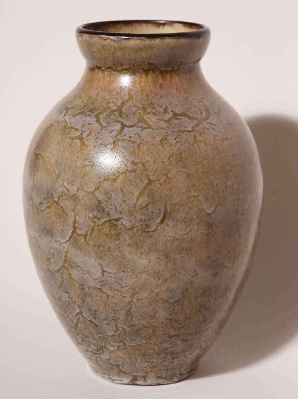 This large stoneware vase with beige rose glaze has circumferential circles around the base and a brown rim.
Signed: 