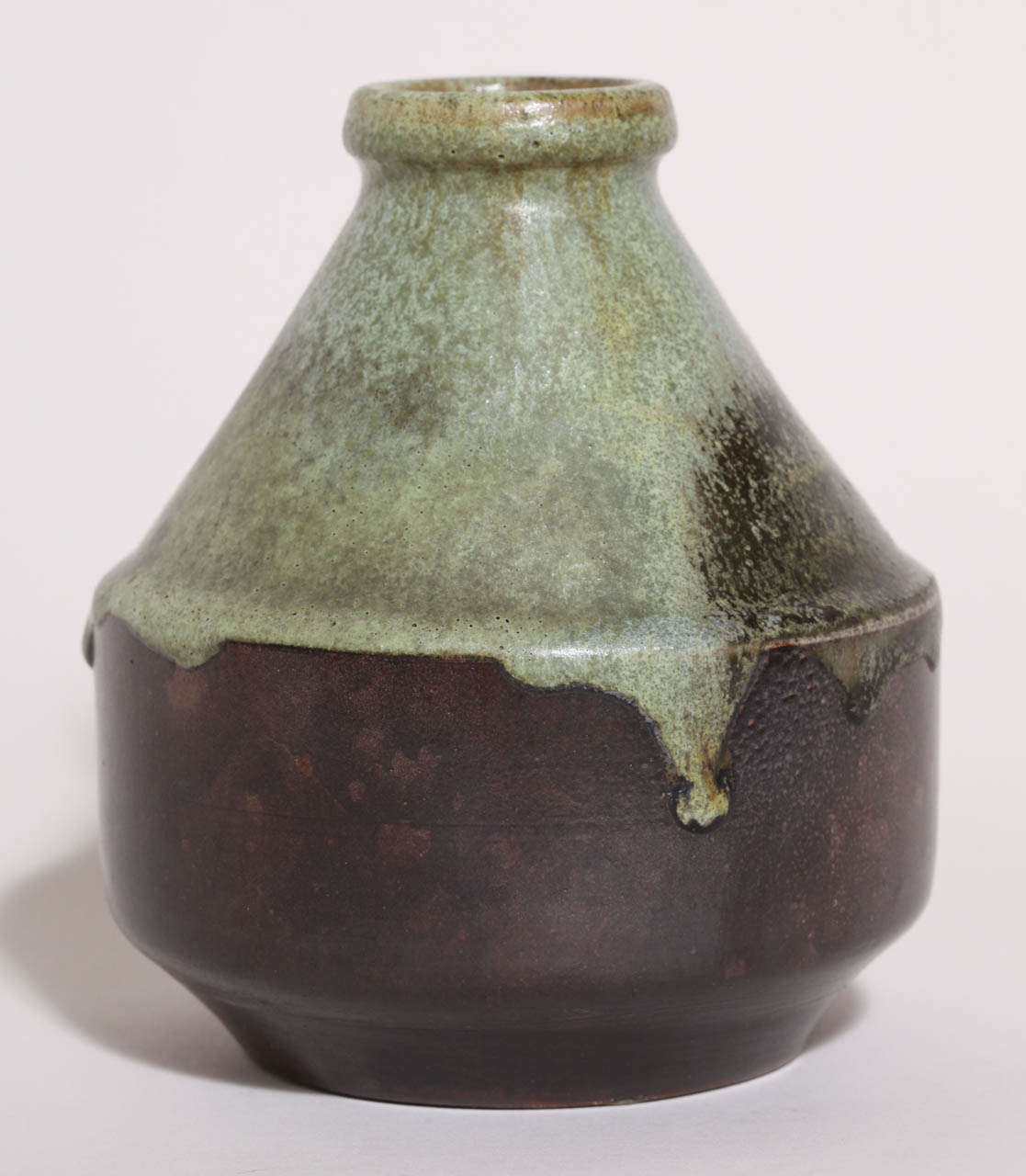 Vase aus Steinzeug mit rundem Absatz, ausgestelltem Boden und zylindrischem, sich verjüngendem Hals, der in einem Ring mit grünem Bronzedekor auf dunkelbraunem Grund endet.
Gezeichnet: 