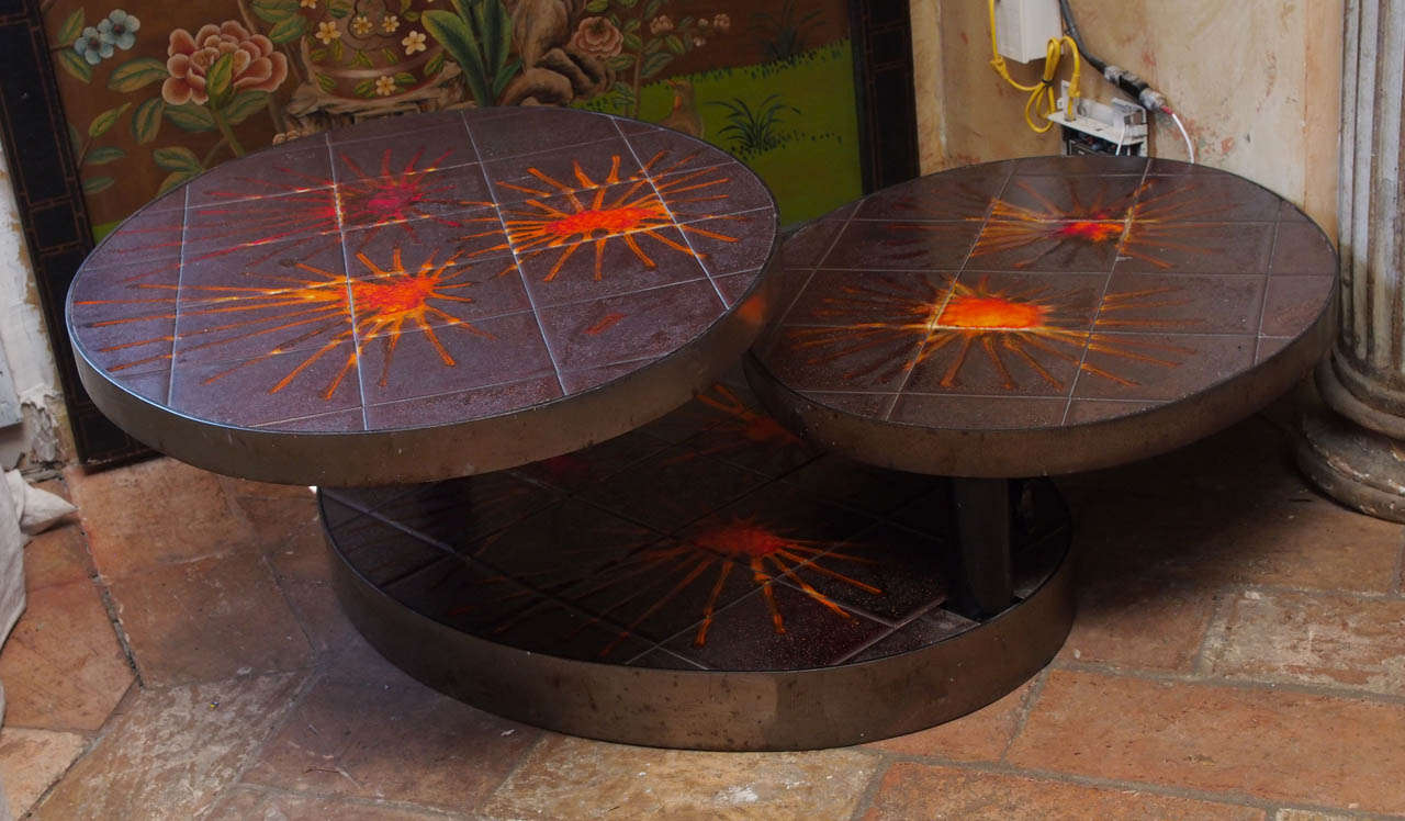 French midcentury iron and ceramic three-tiered coffee table on a swivel base. Signed by Valauris, circa 1950.<br />
