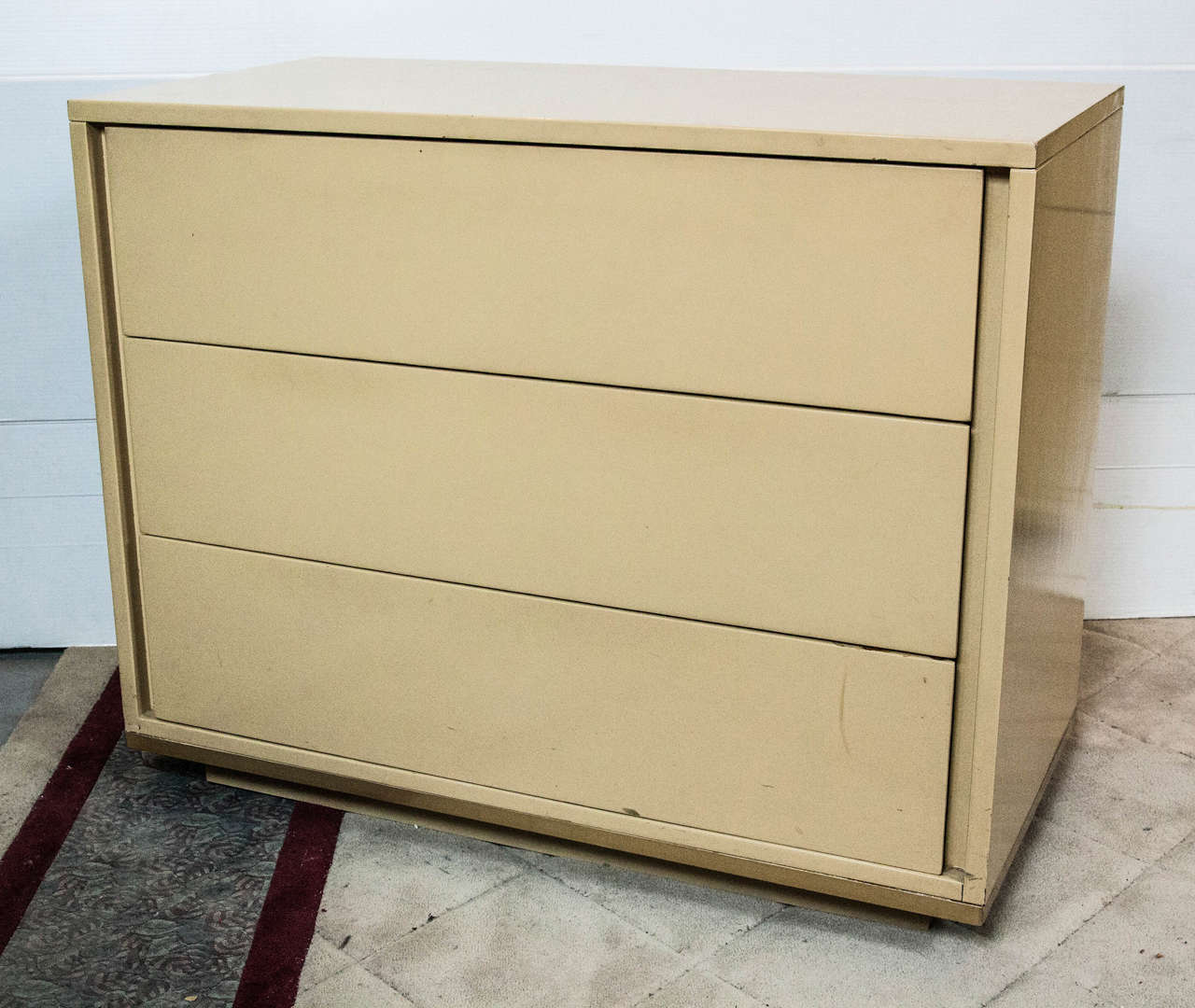 Great pair of John Stuart chests. In a crème lacquer having three deep full drawers. Mid-Century Modern design for crisp clean lines. Stamped John Stuart. There is a matching pair of hi chests which are sold separately.