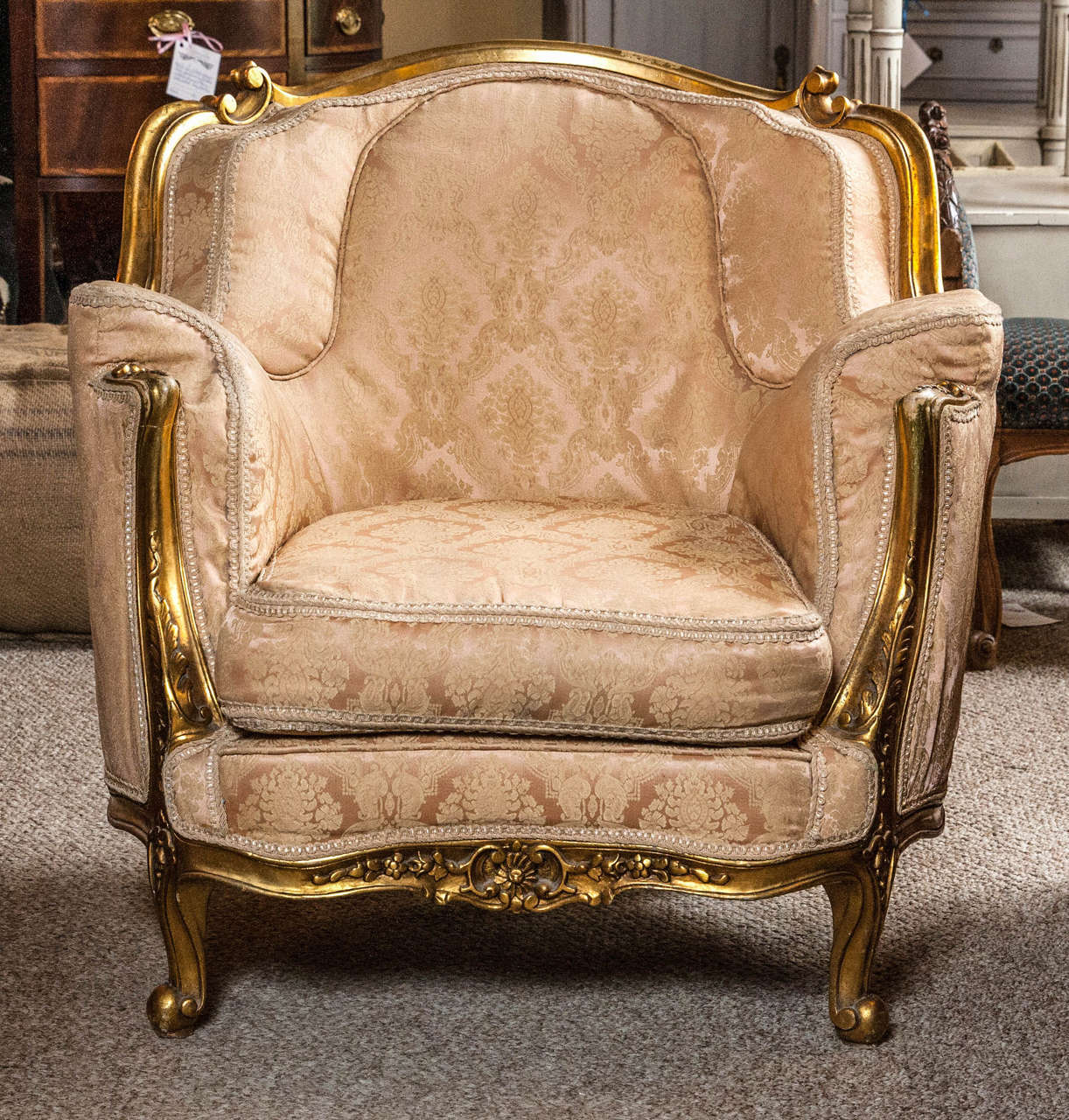 Pair of Louis XV Style Gilt Wood Bergere Chairs. This beautiful antique framed gilt wooden pair of Bergere / Lounge Chairs speak volumes in regards to fashion and flowing design. The pair have double padded back rests and arm rests. The Carved