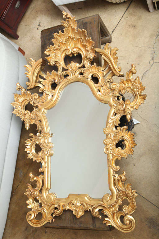 A wall mirror with gilt carved floral frame in high relief, 19th Century