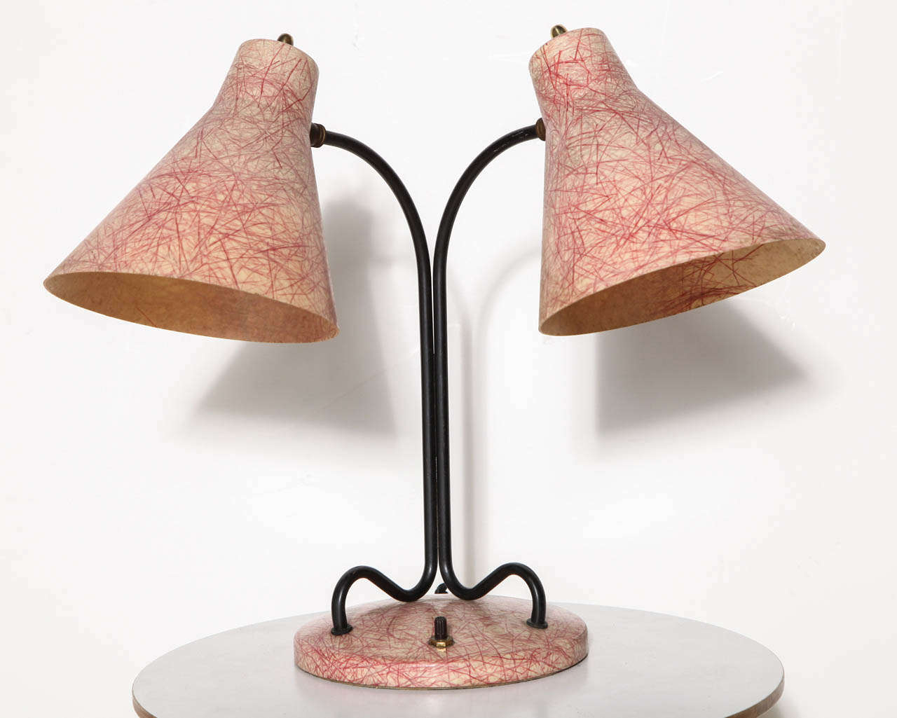 Adjustable Reading Table Lamp with two fiberglass shades in the style of Kurt Versen. Featuring a black enameled loop double stem, ball sockets, perforated, tilting, adjustable double cream with reddish threaded fiberglass shades and round