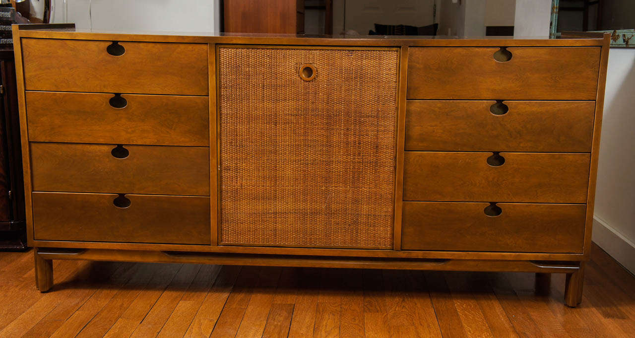 in the manner of Harvey Probber, our credenza offers eight drawers and a closed, center caned section that reveals, three shelves.
charming and unusual, finger-hole pull hardware.