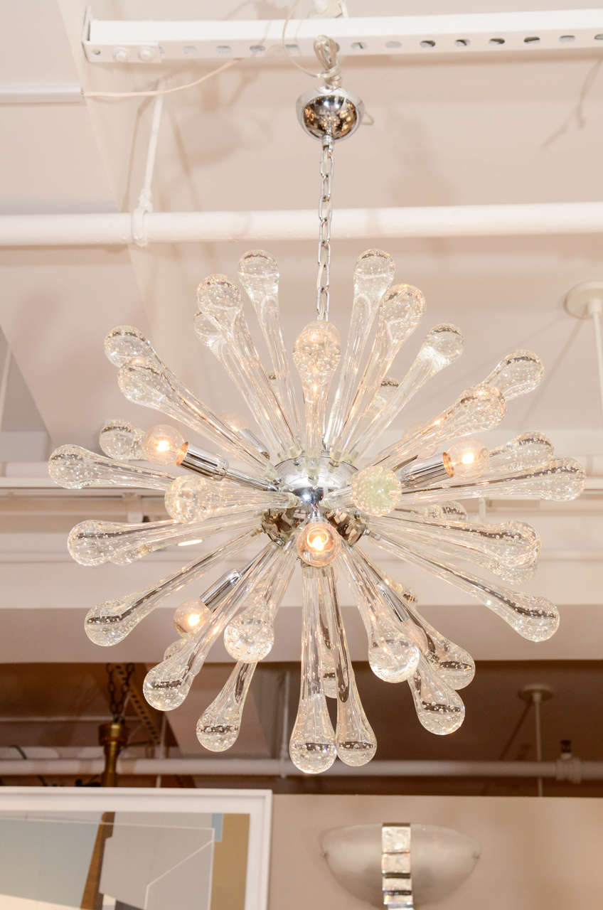 An Italian sputnik chandelier comprised of clear teardrop hand blown
Murano glass rods infused with bubbles, radiating from a chrome globe with nine sockets, newly wired for the American market.