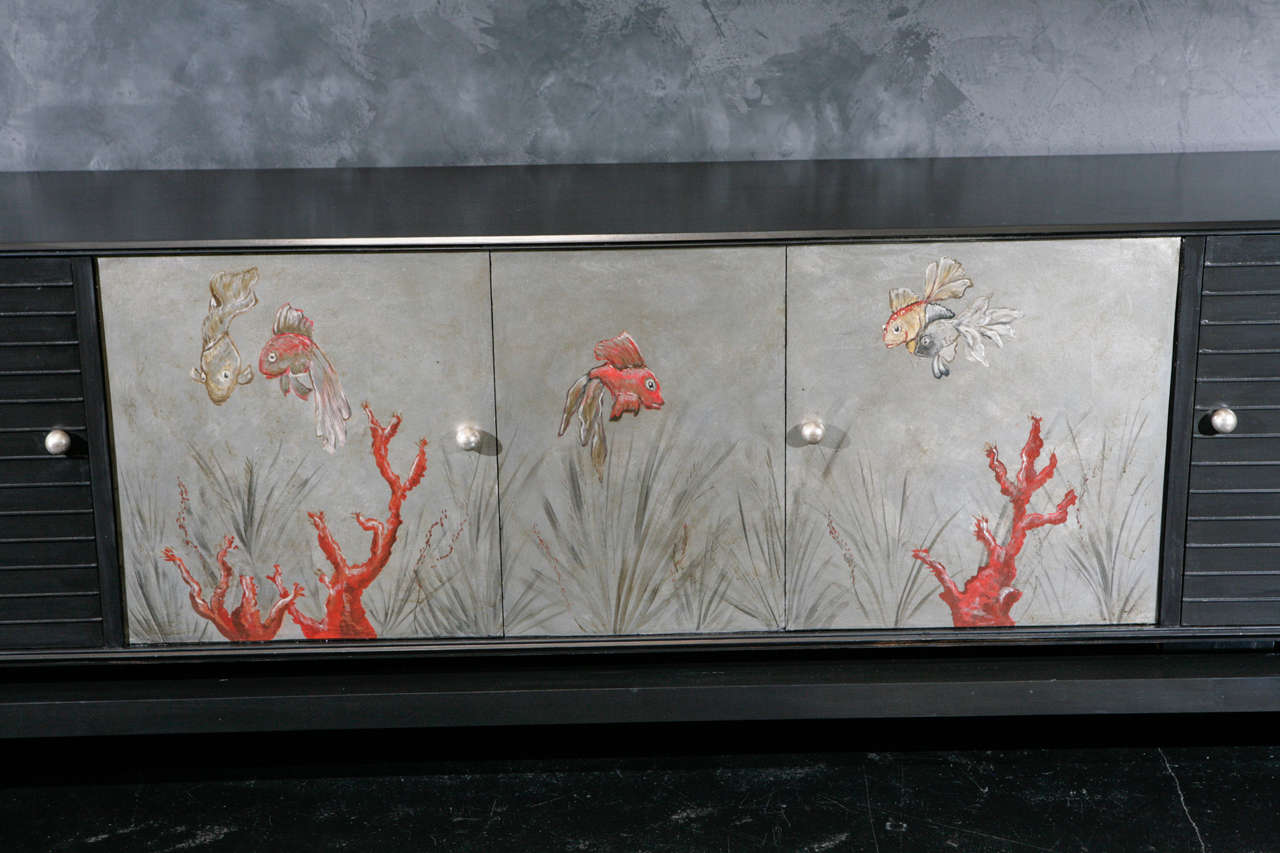 One-of-a-kind sideboard in the style of Jean Dunand hand painted with a fish and coral motif. Paris, 1950's. Matte black finish with painted details on silver leaf and silver paint. Textured side doors and interior shelving and drawers.