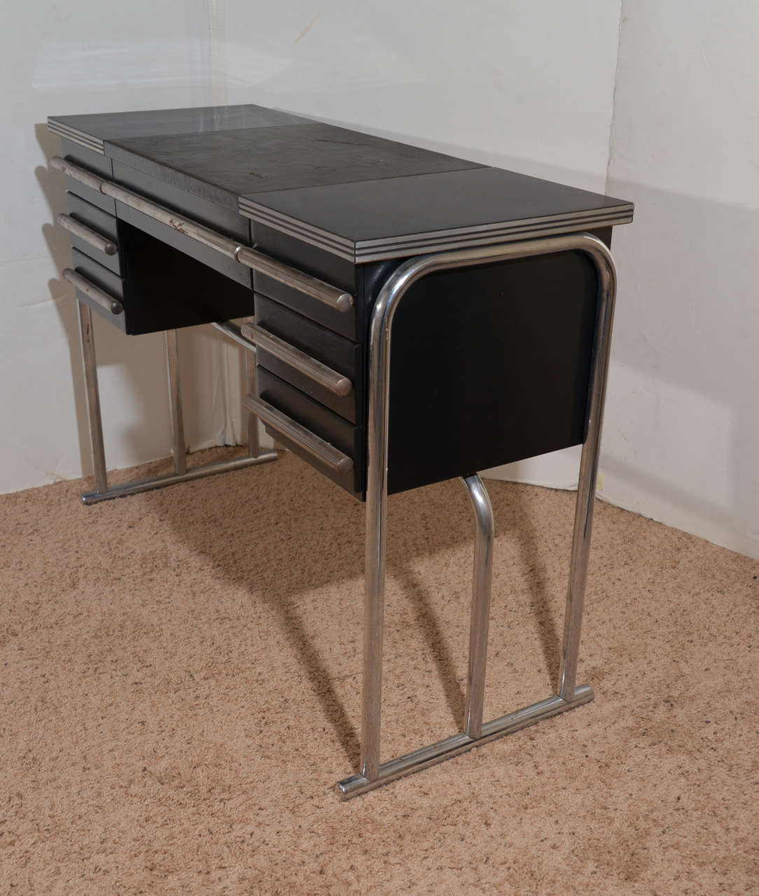 A rare example.  Tubular chrome, bakelite laminate, enameled aluminum and leatherette.

Very cool streamline design.

Good condition, with some wear to leatherette and overall chrome dulling from use.  Laminate top is great.