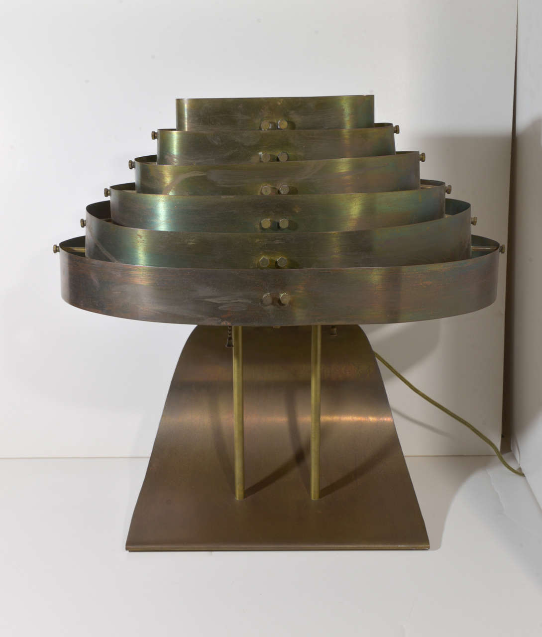 Machine Age Art Deco Kurt Versen bronzed streamline skyscraper table lamp price reduced from $3800

Vintage original condition with beautiful bronze / brass / copper patina.
Nice folded sweeping base with machine age louvered shade.
All hardware