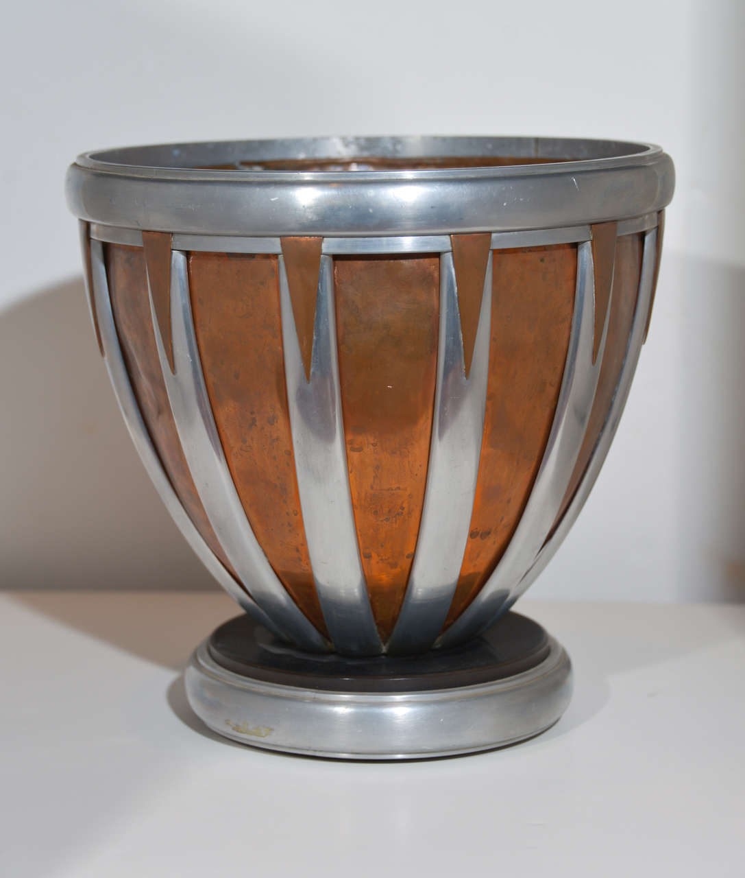 Machine Age Art Deco mixed metal hand wrought vessel vase centerpiece

Fantastic large hand - worked and machined design.
Copper and aluminum (or similar alloy) lattice, thick bakelite disk on wood-wrapped base.
With removable hammered copper