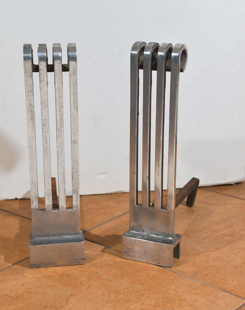 Extruded aluminum and iron andirons originally designed by Donald Deskey in 1929/30.  Andirons and firedogs all stamped 1191,  ca. 1933.  Remnants of original black enamel verso and between tines.  original, as used condition.  Well documented