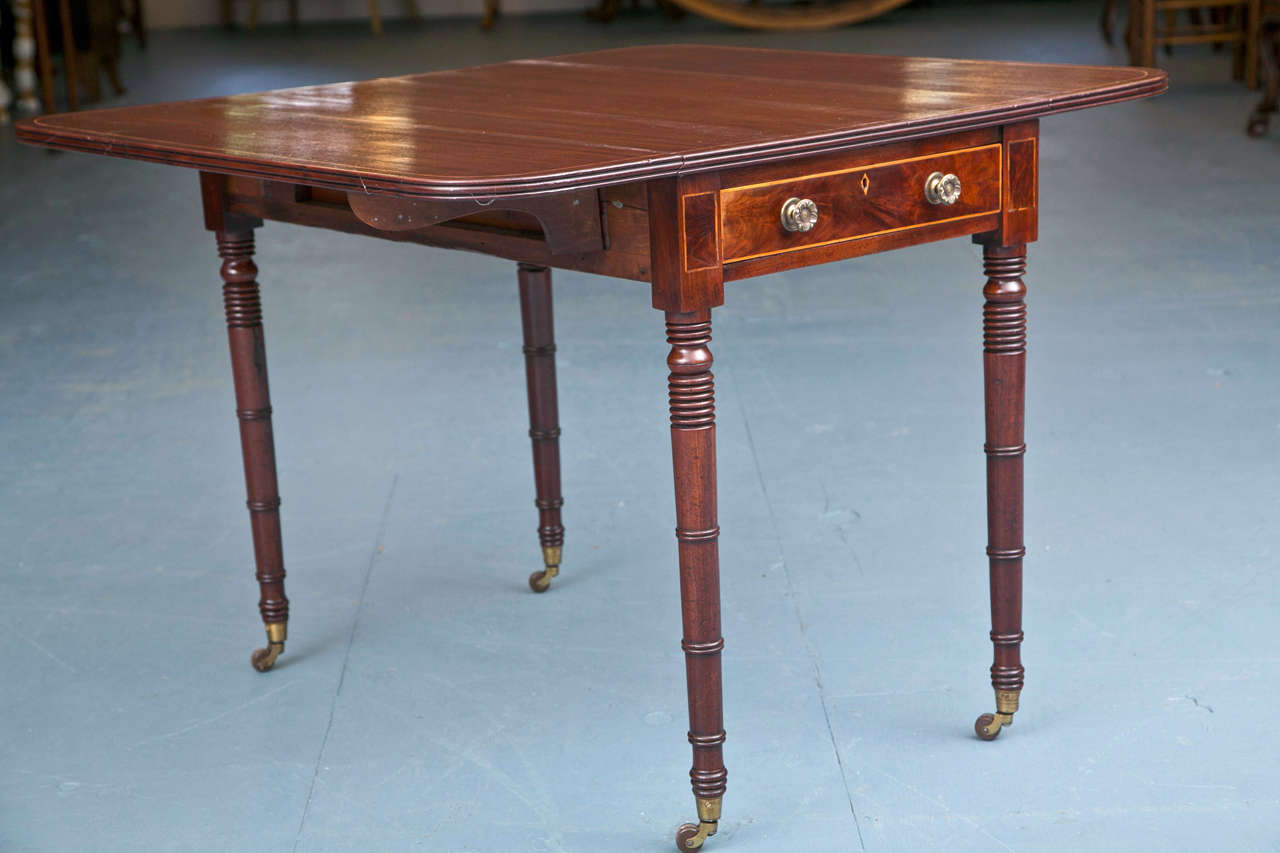 Tightly gathered turnings delineate the legs and attract the eye, but once that original flirtation is over, it is the delicate boxwood string inlay that entices. The top has a reeded edge that evokes the beehive turnings at the top of each leg. The