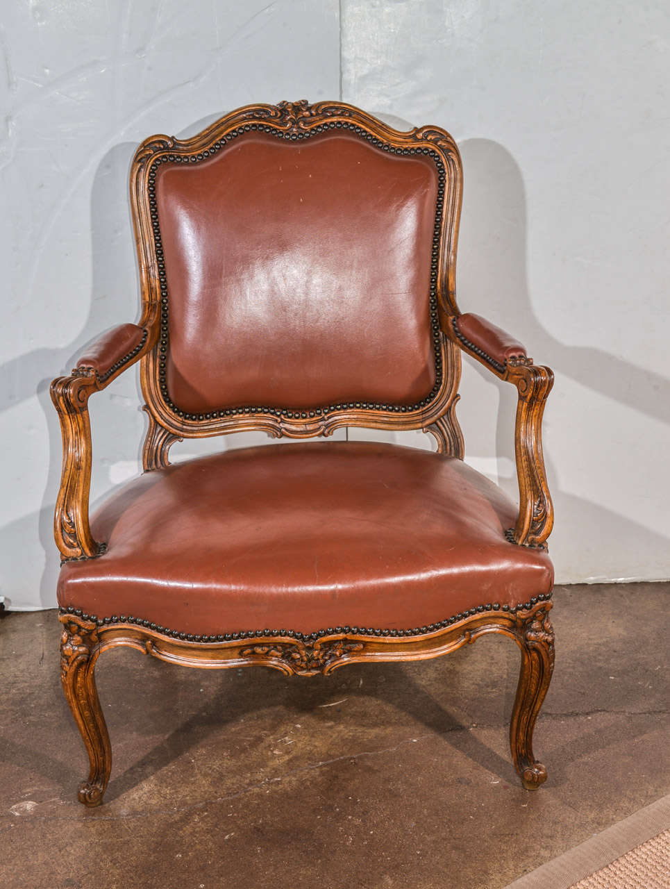 Pair of French carved chairs with leather upholstery.