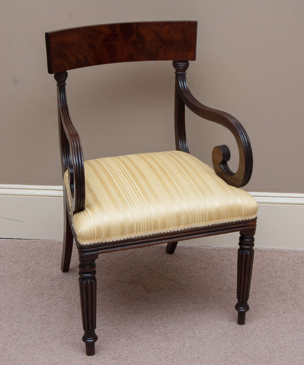 This high style arm chair has a flame mahogany back rail -- very fine hand carving, turning and reeding -- the scroll arms are excellently proportioned -- upholstery is in good shape -- chair is strong and comfortable.