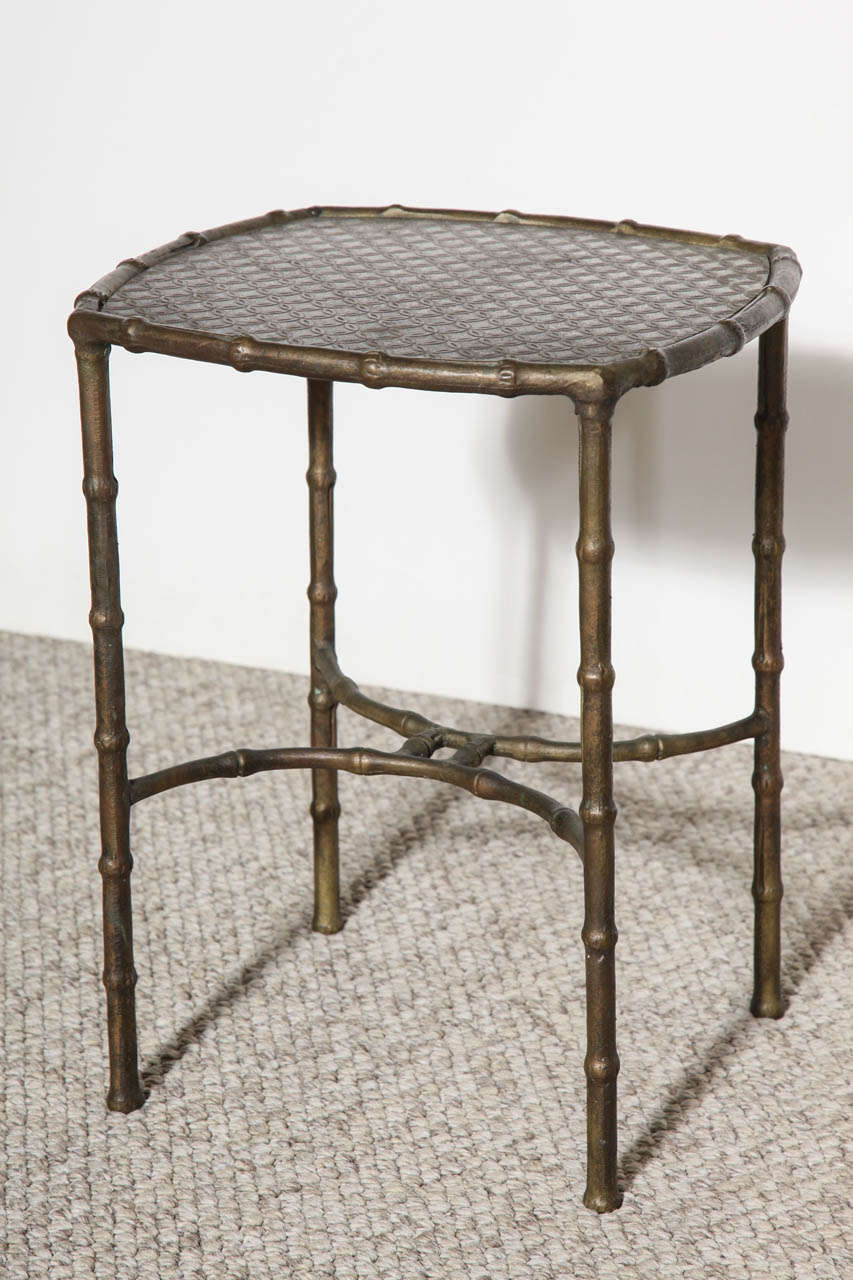 Rare and early side table with faux-bamboo base in bronze.  Top of bronze and pewter with relief pattern of interlocking circles.  Signed on underside.