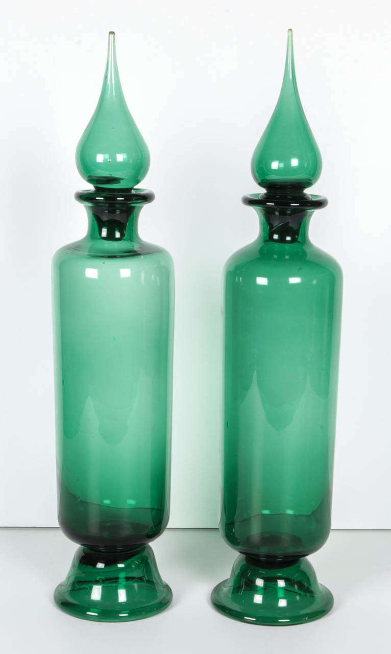 A pair of large emerald green decanter bottles in the manner of Gio Ponti. Stunning in color and in scale.