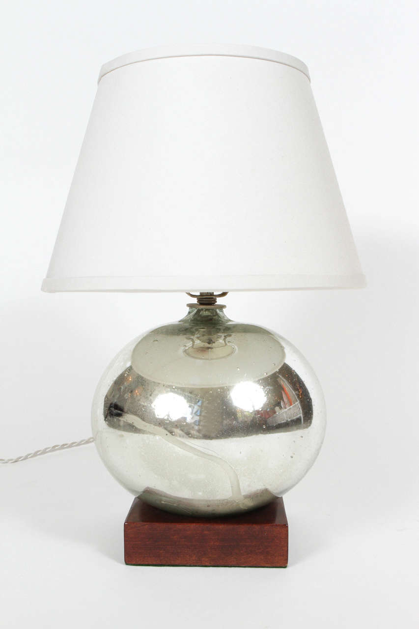 Vintage mercury glass ball made into a custom lamp with wood base and white silk shade.