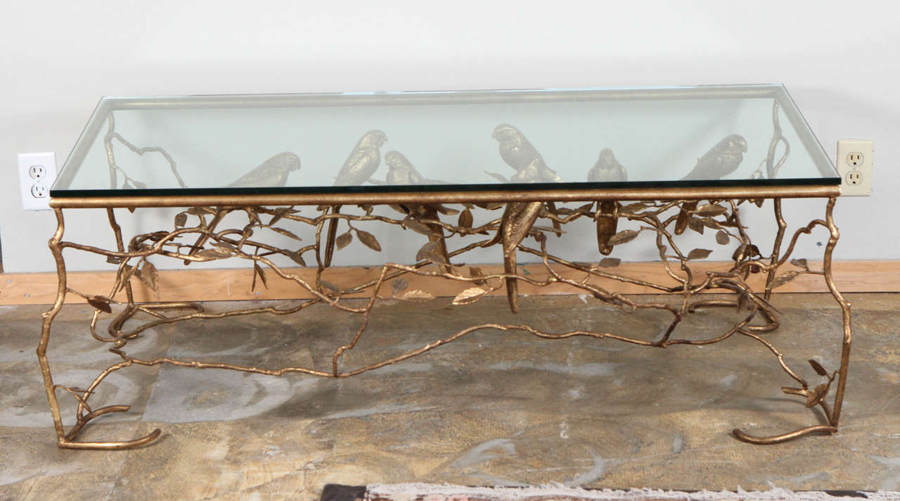 Cast bronze cocktail table featuring faux bois branches, foliage and macaw parrots. Restored with new metal leaf finish and new glass top.
Visit the Paul Marra storefront to see more furnishings and lighting including 21st century