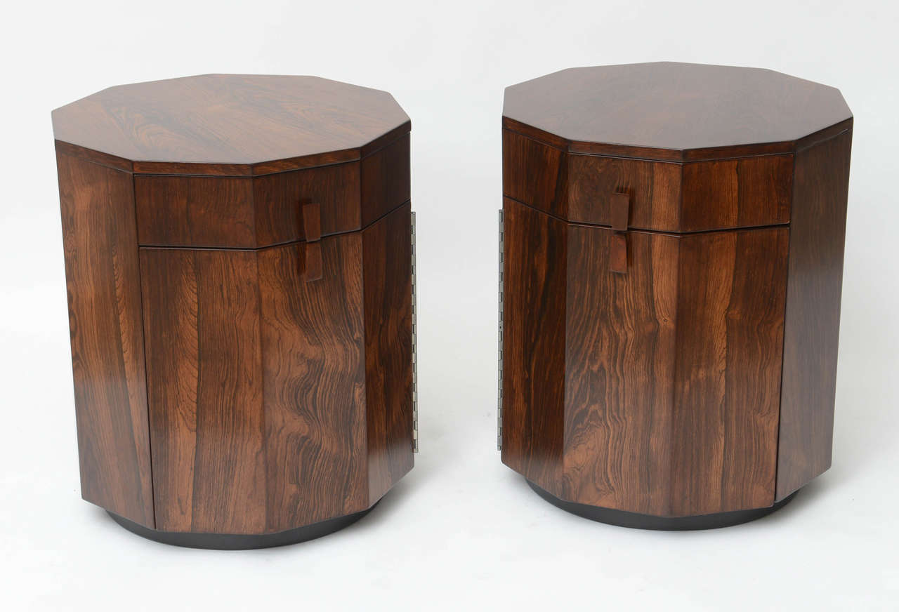Beautiful rosewood inside and out, these 10-sided end tables by Harvey Probber do double duty . Each has a single drawer on top and a piano-hinged door below that opens for storage. Use as end tables, occasional tables, or dry bar. Metal makers