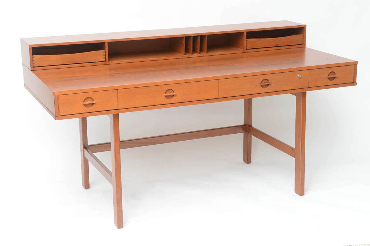 Professionally restored 1960s Jens Quistgaard partners desk in teakwood. Slotted and compartmented gallery with moveable trays can be flipped down to create a partners desk, or in space-challenged apartments, a dining table.
