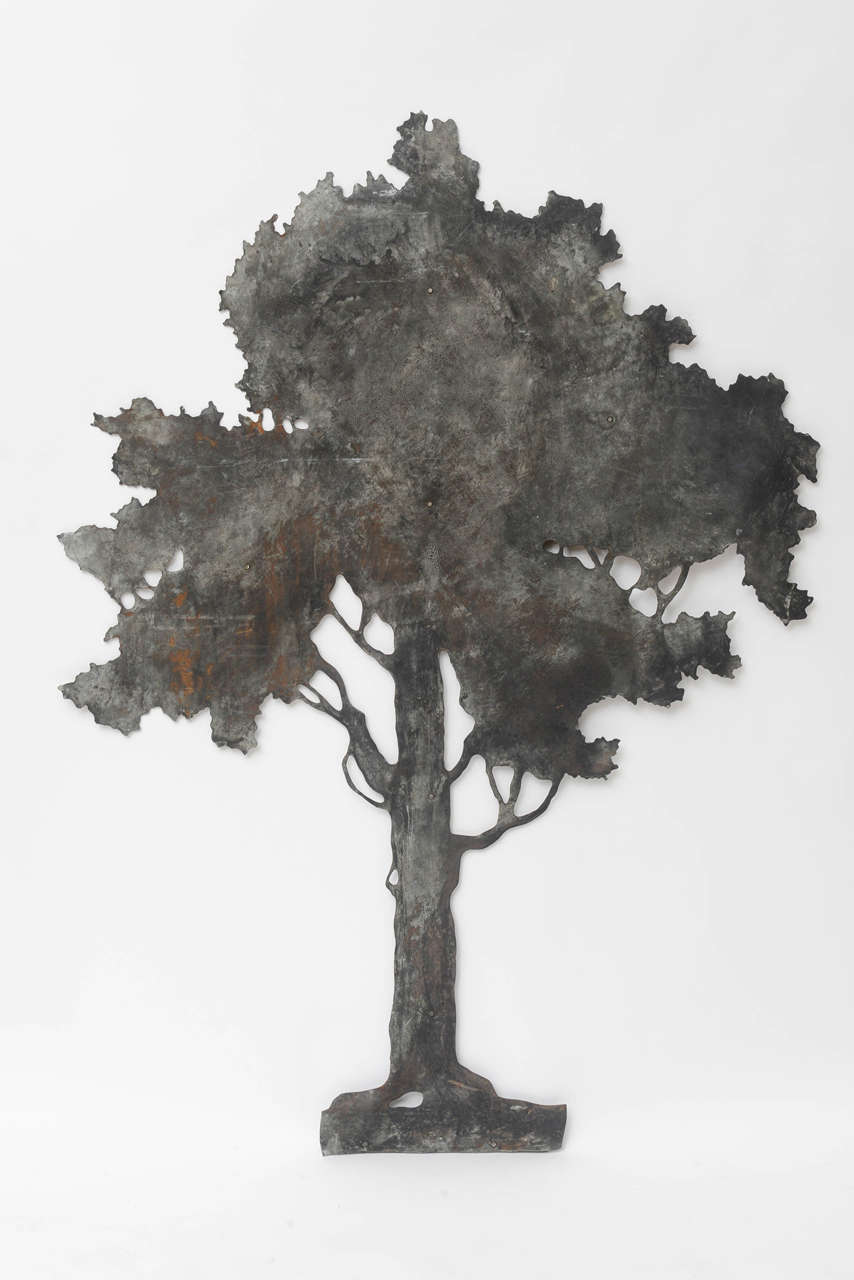 An impressive piece of Folk Art, this painstakingly hand-cut sheet metal tree is looped on back to hang as a wall sculpture. See photos for two other trees in the original group of three. Priced individually. Artist unknown.