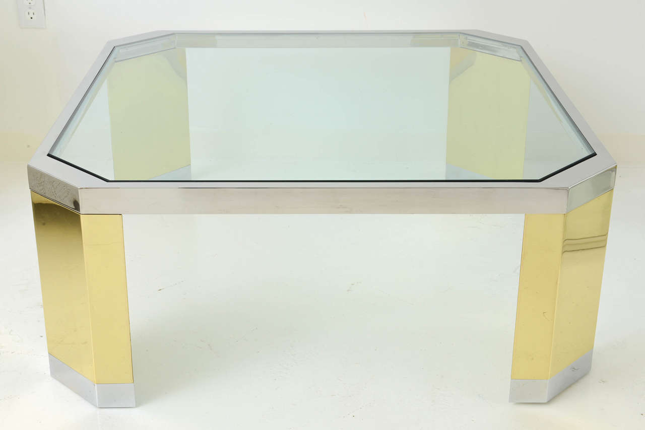 A large, square glass-topped cocktail table by Ron Seff, with style to spare. Polished steel and brass frame with chamfered corners. Beautifully restored.