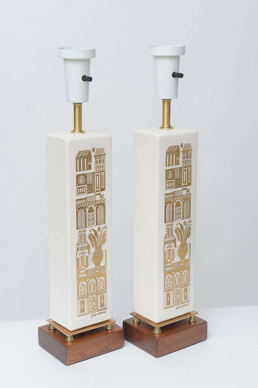 These whimsical lamps by Georges Briard feature delicate gold embossed building facades on matte white ceramic, walnut bases and solid brass details.
