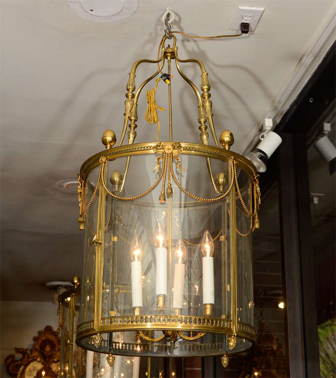 Fine Louis XVI style round gilt bronze four light hall lantern with acorn finials, bow knots and tassels.