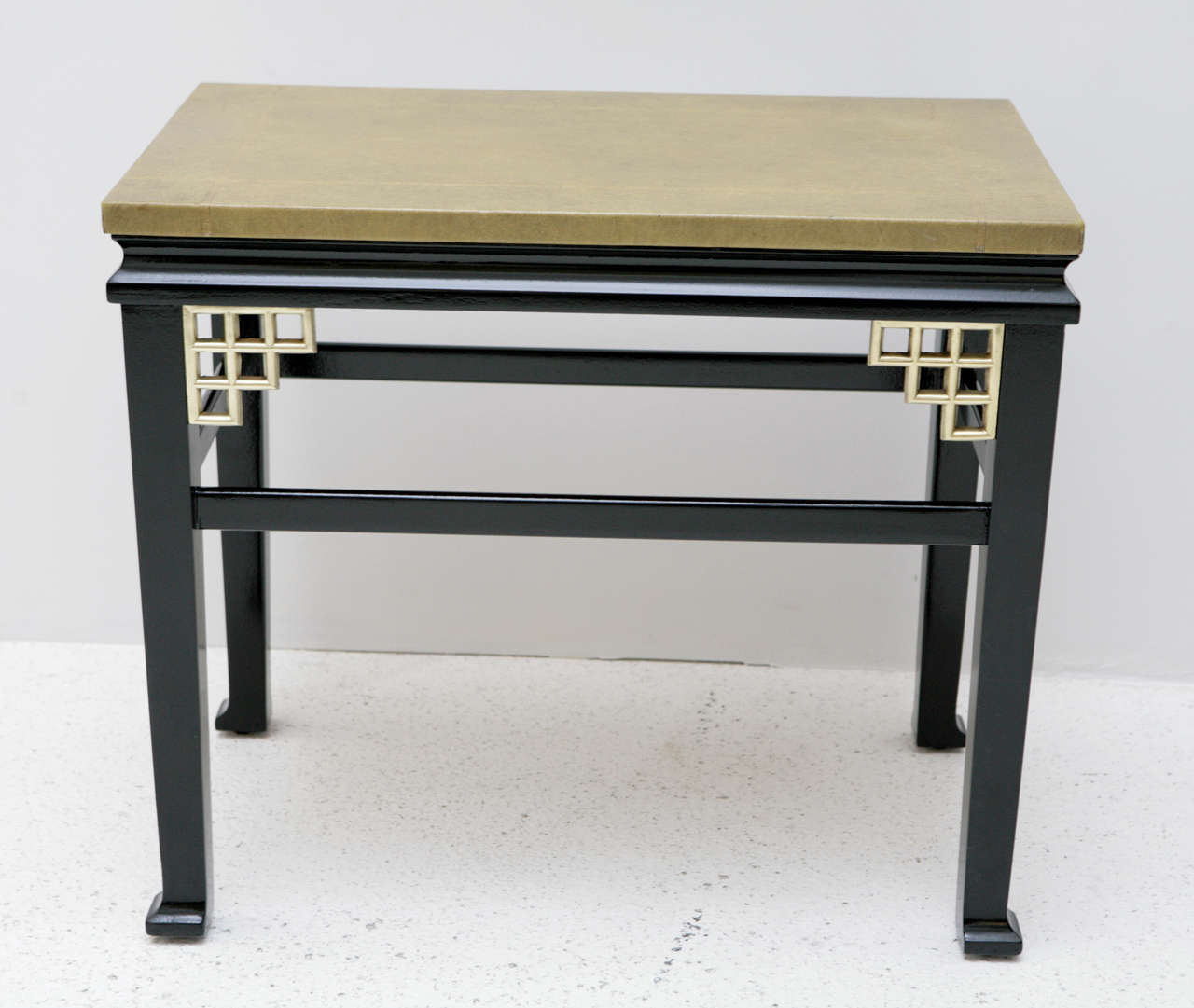 A pair of custom side tables with gold greek key embossed leather tops and satin finished black bases accented with brass fretwork details in the corners.
These tables are most certainly custom work based on the construction and quality, it is