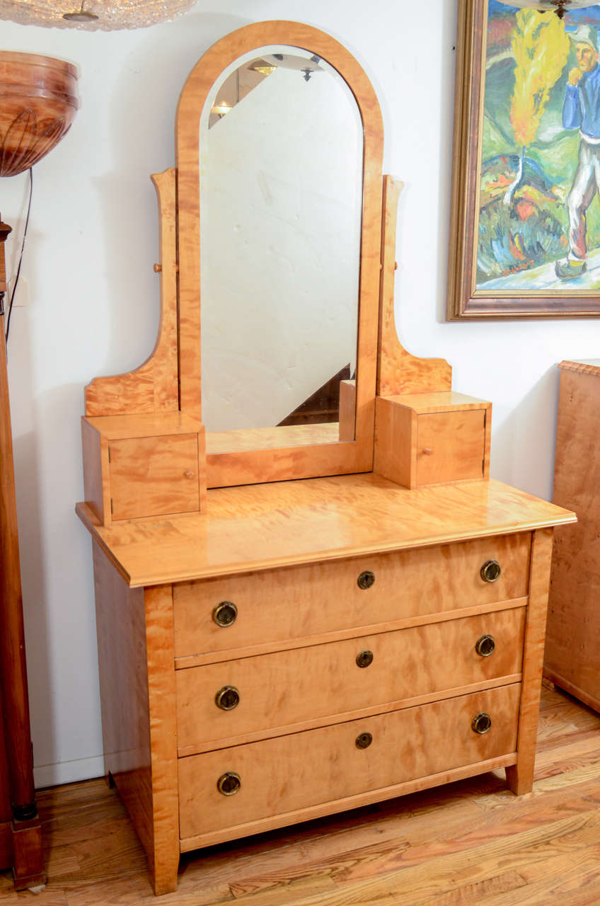 Featuring the qualities of a vanity combined with the functions of a chest of drawers, this tall and handsome piece has three locking drawers for clothing, as well as two generously sized compartments above for perfumes, polishes or jewelry. An