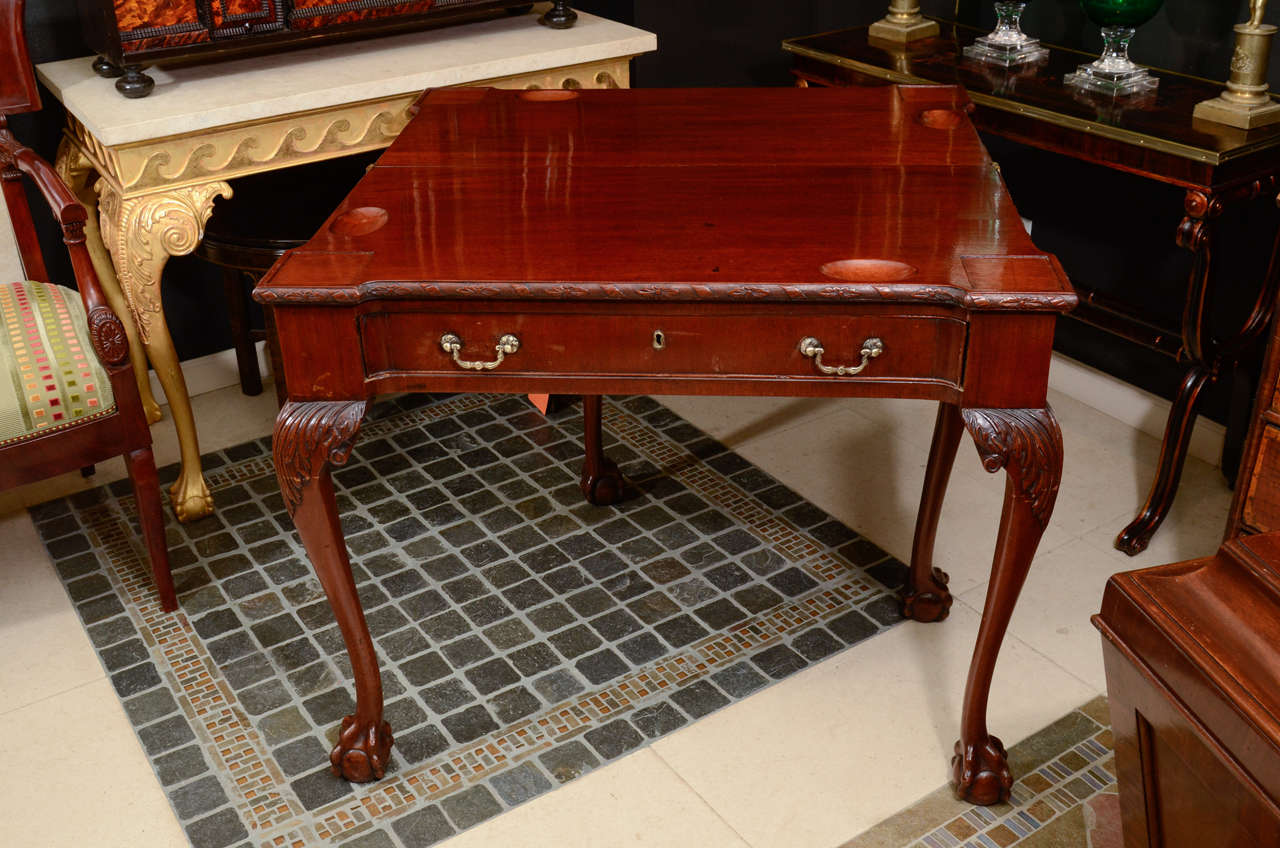 A fine pair of George II carved mahogany games tables with turret corners, acanthus carved knees and ball and claw feet.  