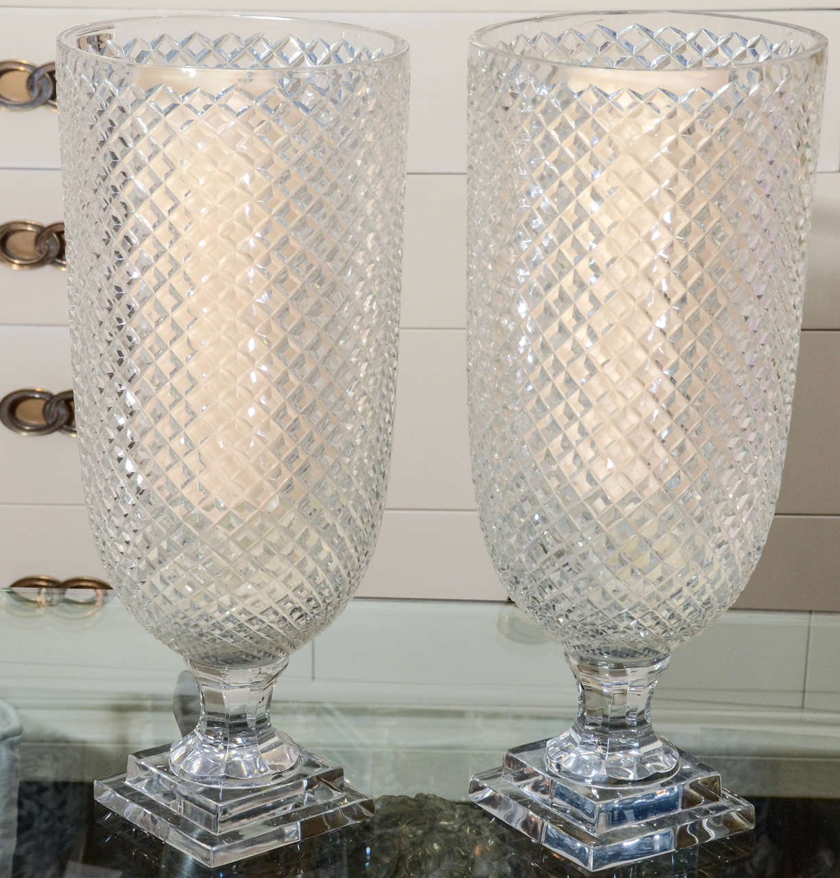 Pair of diamond patterned hurricanes, made in England. They throw an amazing light when a candle is lit within, but look lovely as well as is, can also be a beautiful vase.