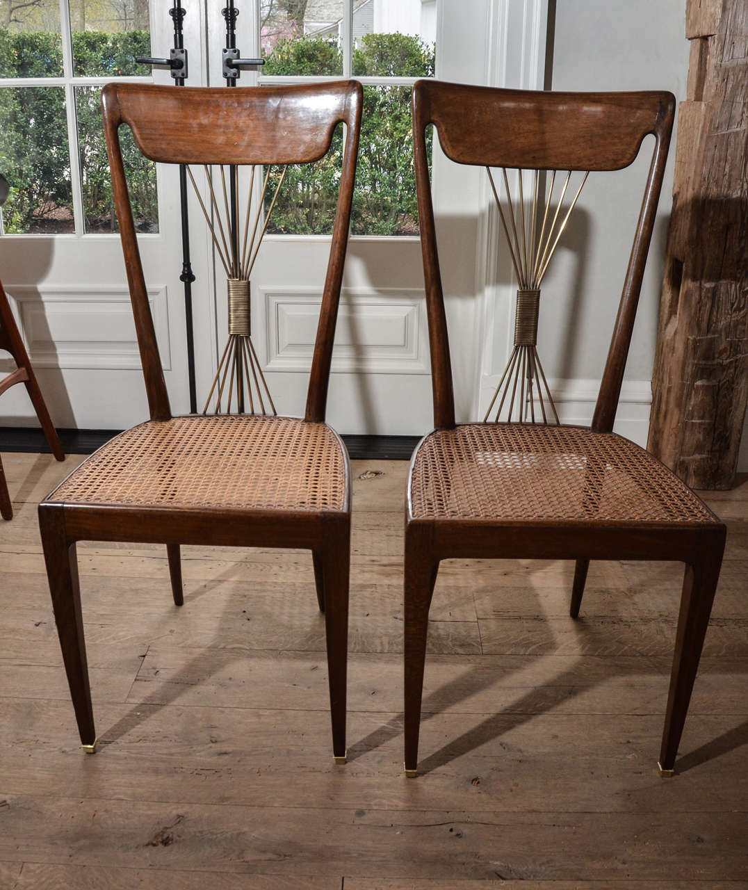 Exquisit pair of 1950s six Paolo Buffa dining chairs in rosewood with original caning inspired by the French Art Nouveau. The center back shows beautiful seven cords made out of brass, adding a very sophisticated and elegant touch to the chairs yet