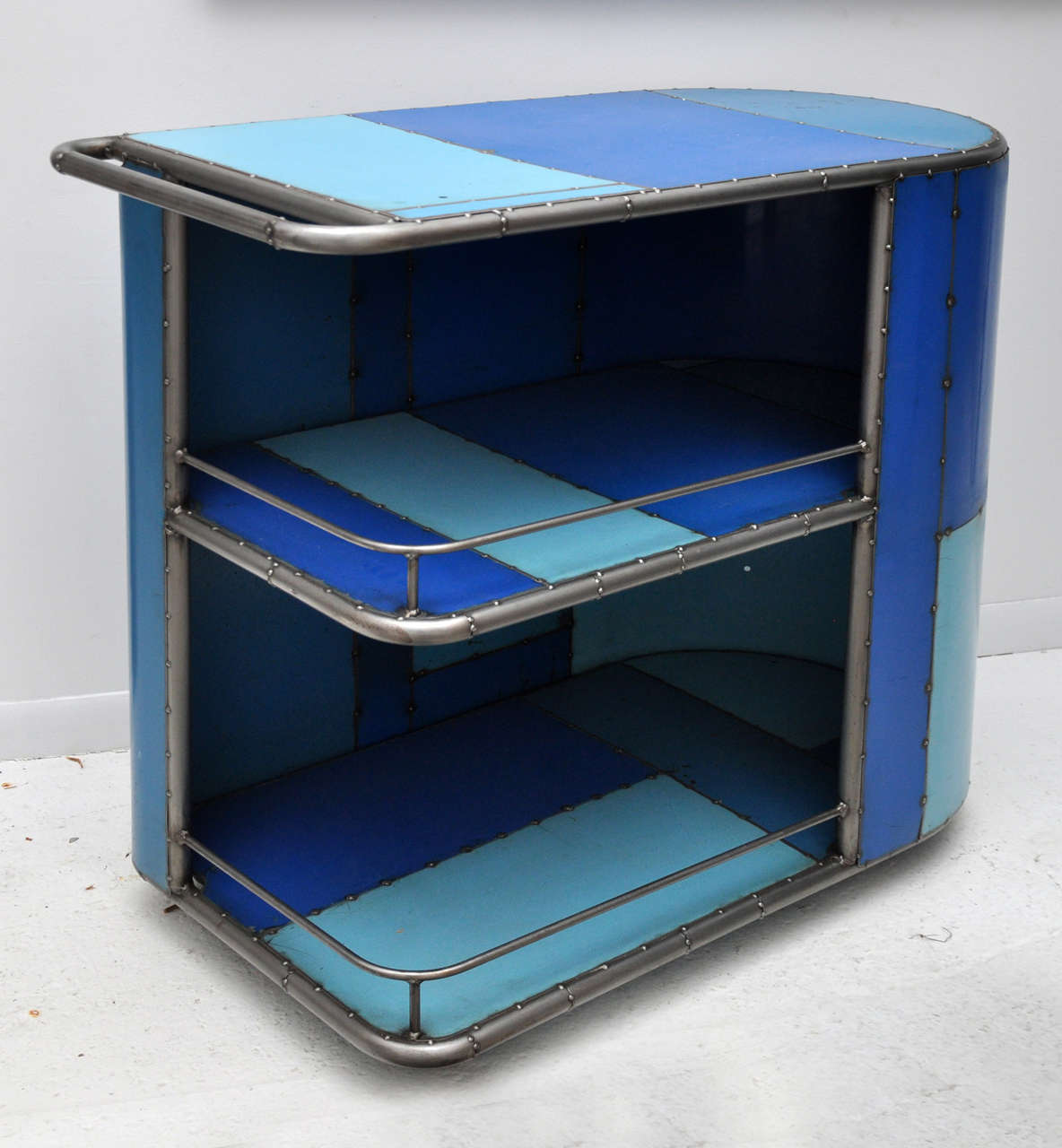 Enjoy a drink from this bright, fun blue bar cart! Crafted from recycled sheet metal and blue shelving from an old GM plant. Castered.