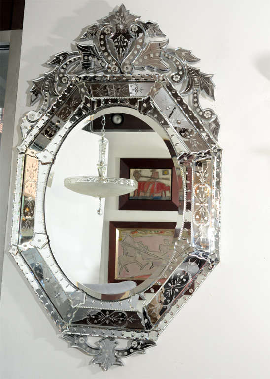 Reversed, Etched, and Beveled with great pediment details. This mirror is in outstanding condition.It features a elaborate mirrored surround with reverse etched floral sprays and ornate pediment top .