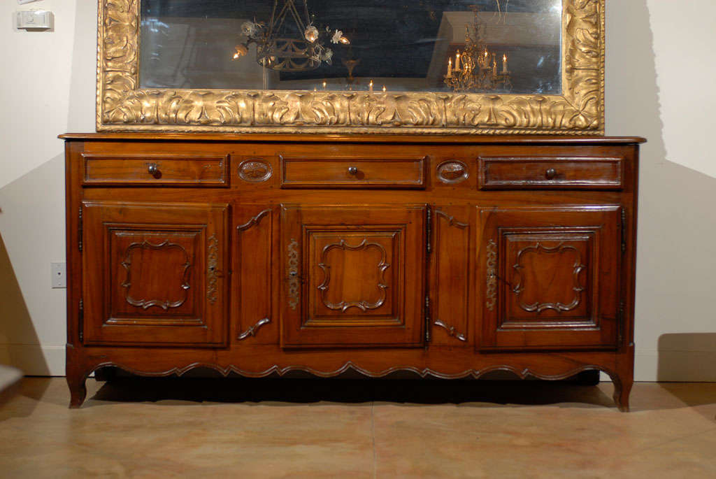 A French walnut enfilade from Burgundy with three drawers and three doors from the 18th century. This French walnut enfilade was born in the 18th century, during the reign of King Louis XV, which saw the development of the Rocaille style in France
