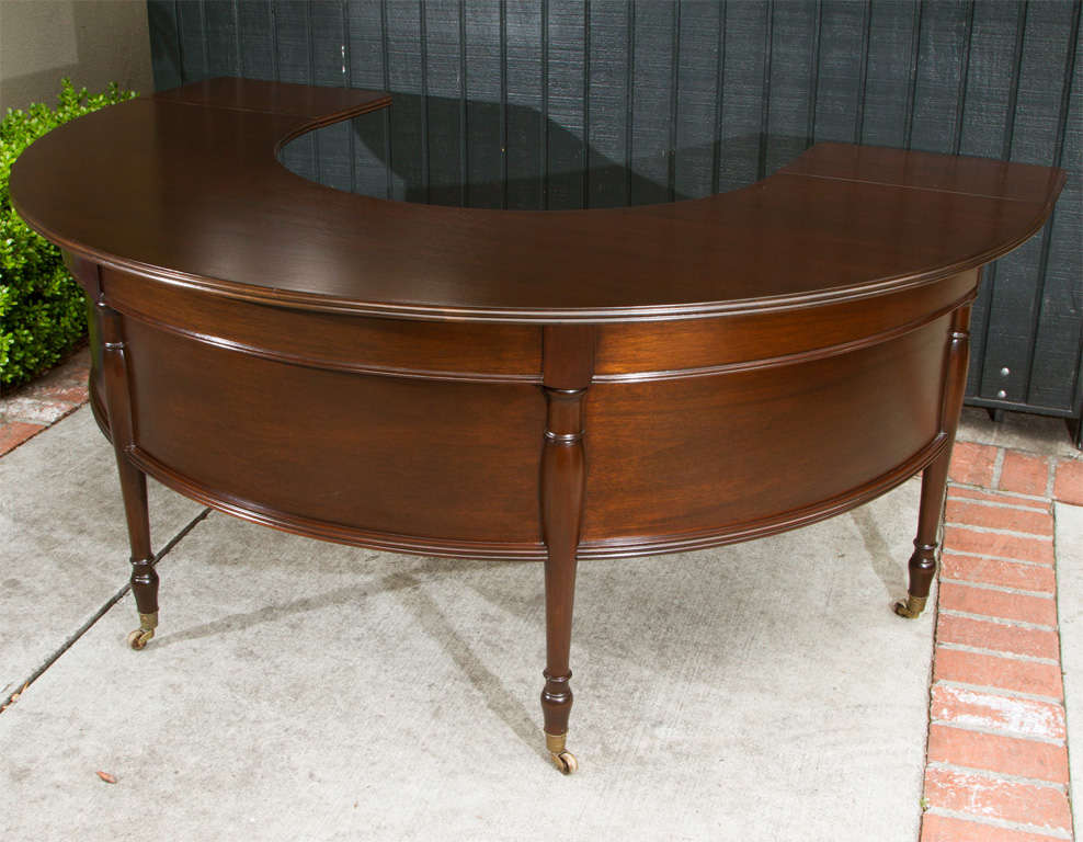 Vintage U shaped walnut writing desk with drawer and drop down leaves on castors.