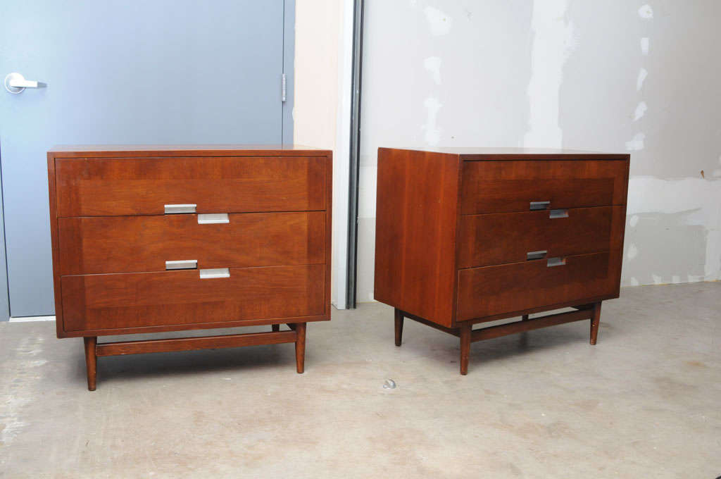 Pair of 3 Drawer Dressers featuring decorative aluminum inlaid pattern at corners and cast aluminum pulls. 
The book matched walnut veneer on front panels, solid wood tapered legs with the stretcher add a lot of character to these very fine